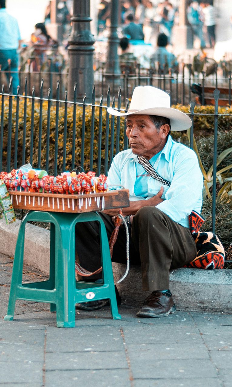 a man selling candy on the street in a foreign country