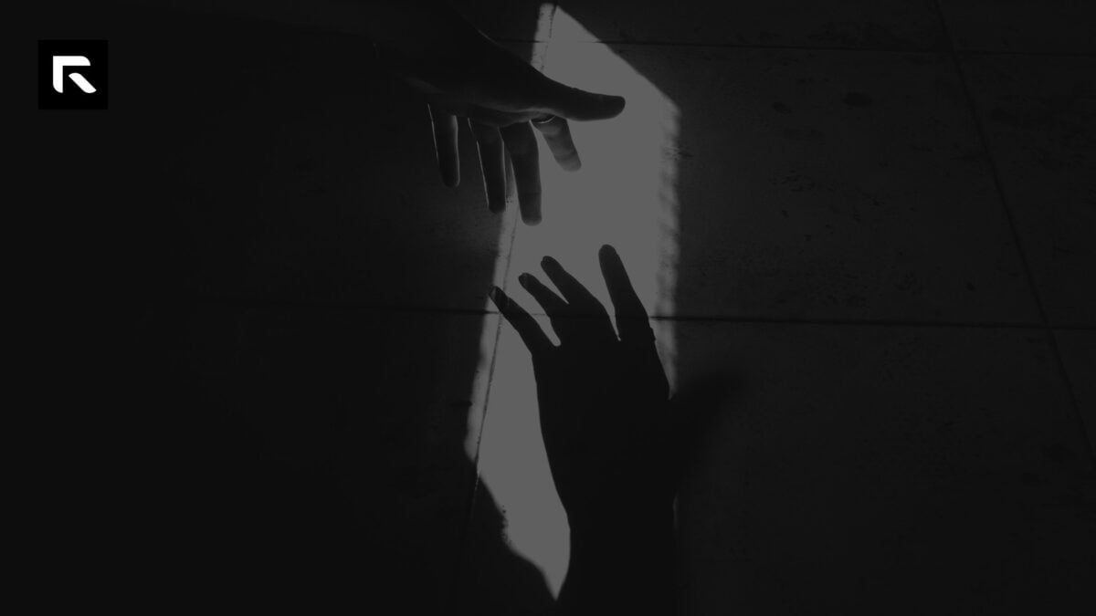black and white photo of a hand reaching out to it's shadow