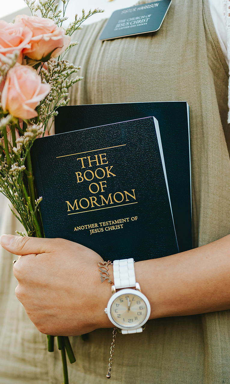 a woman holding the book of mormon
